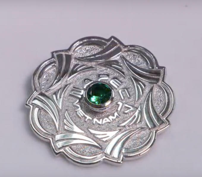 Huy hiệu trắng gắn đá màu xanh lá peridot dành tặng các bộ trưởng. Ảnh: HOÀI AN.
