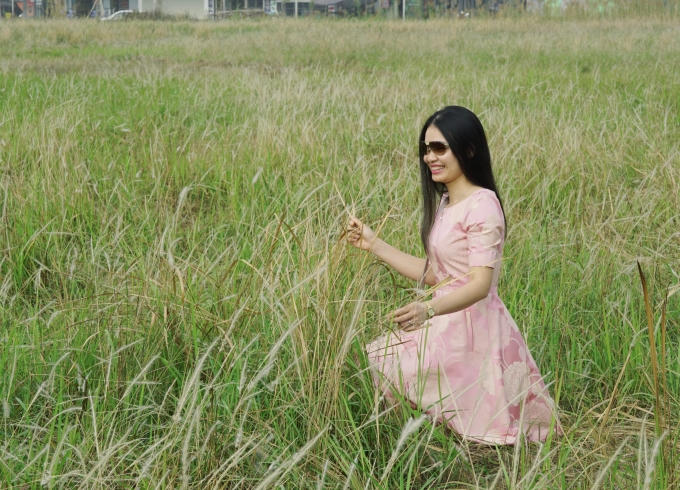 Cô gái thích thú tạo dáng bên vườn lau.