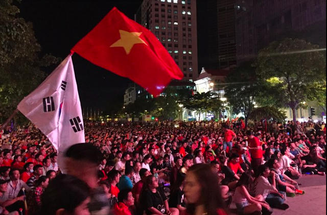 Người hâm mộ cổ vũ đội tuyển Việt Nam trong trận bán kết lượt về với Philippines tại phố đi bộ Nguyễn Huệ (ảnh: Phạm Nguyễn)