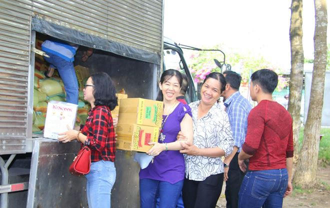 Mọi người cùng nhau vận chuyển gạo và các nhu yếu phẩm vào trao cho bà con nghèo. Ảnh Thành Thật.