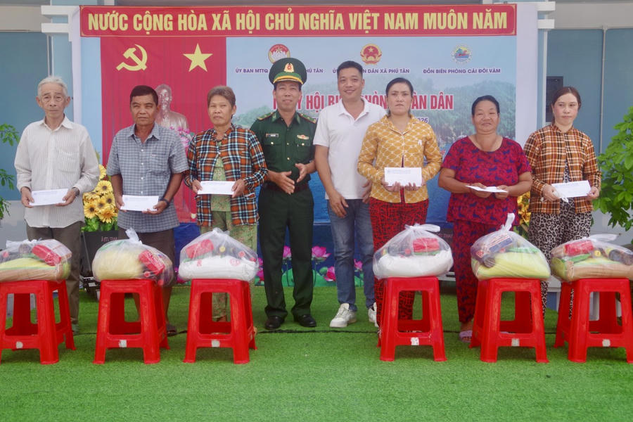 Ông Nguyễn Tuấn Khanh, đại diện nhóm thiện nguyện anh em tại TP. Hồ Chí Minh và Thiếu tá Bùi Văn Hào - Bí thư Đảng ủy, Chính trị viên Đồn Biên phòng Cái Đôi Vàm, trao quà cho các hộ dân có hoàn cảnh khó khăn.
