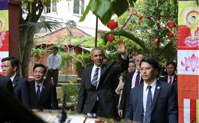 Tổng thống Obama mỉm cười, vẫy tay chào mọi người.