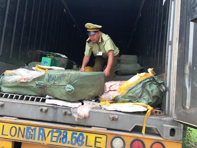Bốc dỡ số lượng thực phẩm bẩn từ trên xe container xuống.