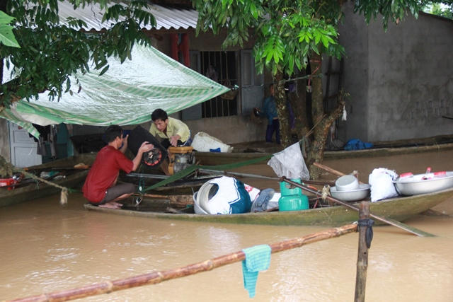 Nhiều người dân vùng lũ phải tá túc ngay trên thuyền cầm cự với lũ. (Ảnh: A.Thắng)