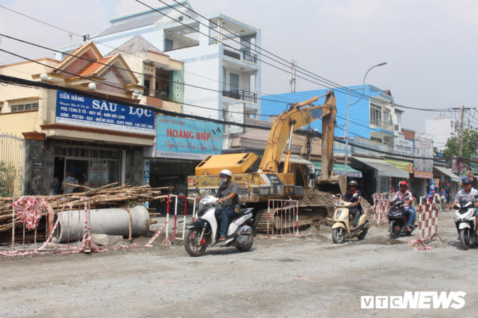 Người tham gia giao thông căng mình luồn lách qua những lô cốt, rào chắn.