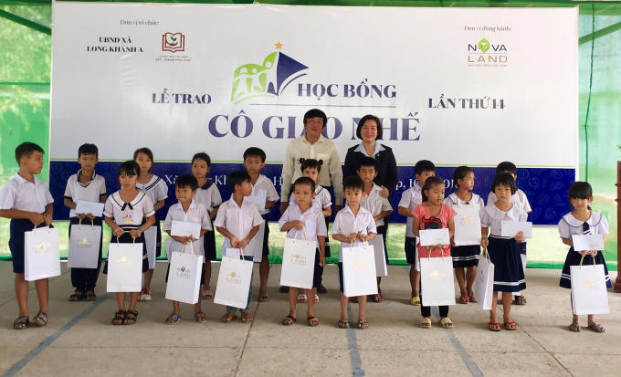 Đại diện Tập đoàn Novaland và lãnh đạo địa phương trao học bổng đến các em học sinh hiếu học.