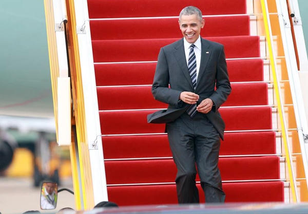 Ông Obama bước xuống sân bay Tân Sơn Nhất trong chiếc áo sơ mi trắng, vest đen. Ông tươi cười vẫy tay chào mọi người đang đón ở sân bay.(Ảnh: Vnexpress)