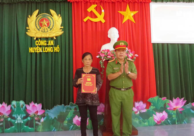 Bà Trần Thị Xuân Tươi (mẹ của Đạt) nhận quyết định thăng cấp quân hàm do Đại tá Trần Văn Thắng, Trưởng Công an huyện Long Hồ trao.