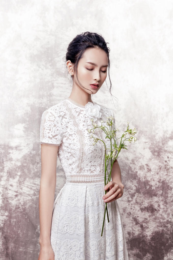 Huyền Trang thanh lịch trong chiếc đầm ren trắng tay ngắn. Kh&ocirc;ng chỉ sử dụng chất liệu xuy&ecirc;n thấu c&ugrave;ng phom d&aacute;ng chữ A quen thuộc, mẫu thiết kế c&ograve;n điểm xuyến th&ecirc;m một b&ocirc;ng hoa trắng đầy tinh tế, tạo điểm nhấn cho người mặc.