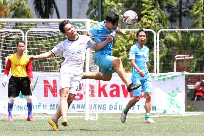 Cầu thủ Lê Hoàng (Áo xanh) của Liên quân Báo Thể thao trong 1 pha tranh chấp.