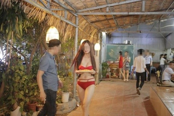 Cô gái diện đồ bikini thản nhiên bưng đồ ăn cho khách trong buổi khai trương của một nhà hàng ăn tại Cầu Giấy, Hà Nội. Ảnh: internet.