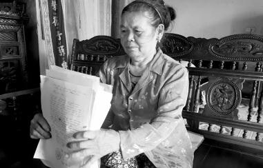 Bà Báo mệt mỏi với đống hồ sơ giấy tờ nhiều năm theo kiện.