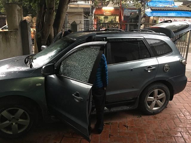 Chiếc xe ô tô của vợ anh Kiên đỗ trong sân nhà dính nhiều vết đạn trên thân và kính xe.