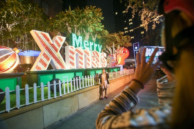 Thanh Mai (23 tuổi) cùng bạn trai đi dạo phố, chụp hình Noel ở tòa nhà trên đường Hai Bà Trưng. "Ngày cuối tuần chắc đông lắm nên mình tranh thủ đi chơi ngày thường khỏi phải chen lấn", Mai chia sẻ.