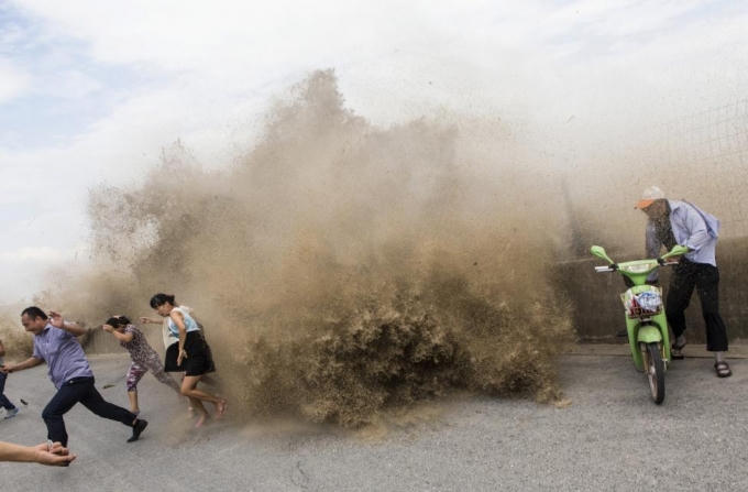 Du khách bỏ chạy khi cơn bão Trami mang theo sóng thần đổ bộ vào tỉnh Triết Giang năm 2013. (Ảnh: Reuters)