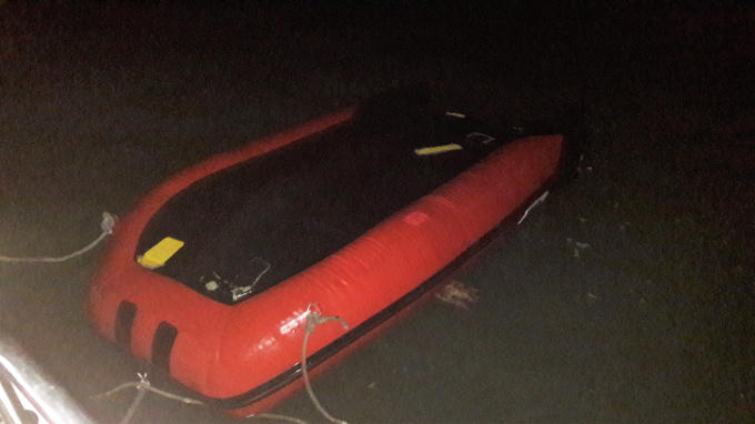 Chiếc xuồng cao su bị lật &uacute;p tr&ecirc;n biển.