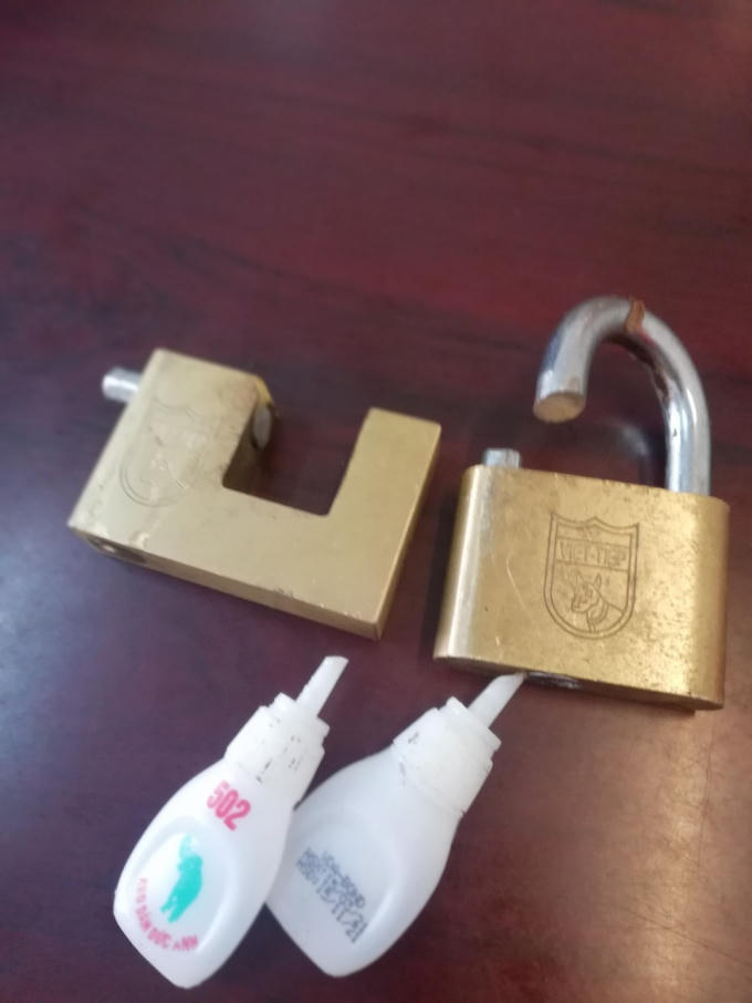 Hai ổ khoá đã bị ông Vinh cắt kèm theo hai lọ keo con voi 502 mà nhóm người lạ mặt dùng để nhỏ vào ổ khoá nhà ông Vinh.