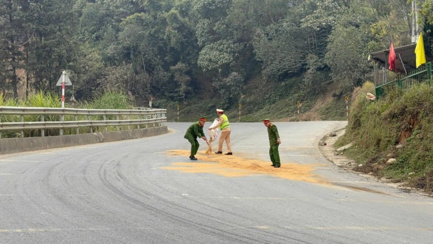 Lực lượng chức năng xử lý vết dầu loang trên đường. (Ảnh: Công an Lào Cai).
