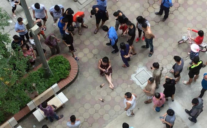 Nạn nhân sau khi bị bắn ngồi bệt ngay tại sân chung cư VOV.
