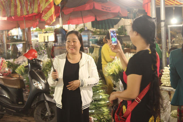 Kh&aacute;ch đứng tuổi cũng đến chợ hoa để chụp ảnh.