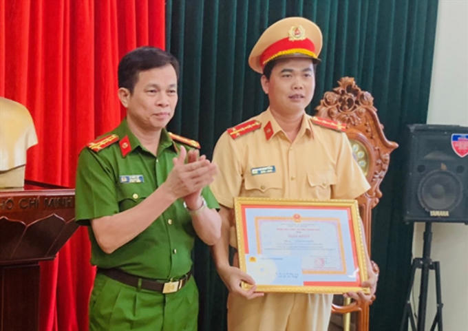 Đại tá Lê Như Lập, Phó Giám đốc Công an tỉnh Thanh Hóa trao bằng khen cho đại úy Lê Đăng Giang.