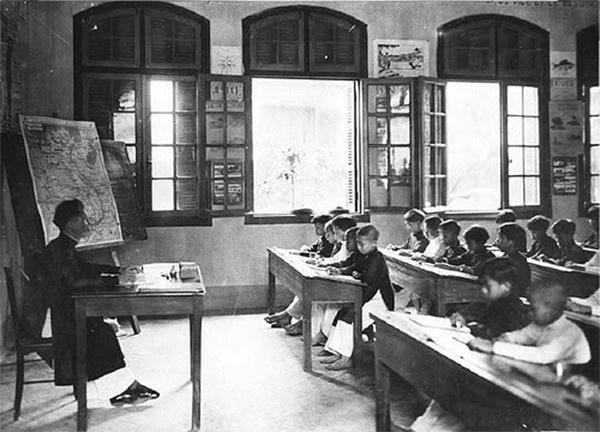 Lớp học dưới thời Pháp, các em học sinh bắt đầu được học chữ quốc ngữ.