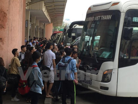 Rất đông hành khách tập trung trước xe khách để lên xe về quê. (Ảnh: Việt Hùng/Vietnam+)