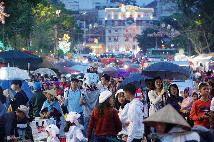Trước đó, khoảng 18h, trời đổ mưa nhẹ. Đang trong kỳ nghỉ cùng gia đình, anh Minh Ngọc (du khách TP HCM) dùng dù (ô) để che cho con gái trong lúc vào chợ.