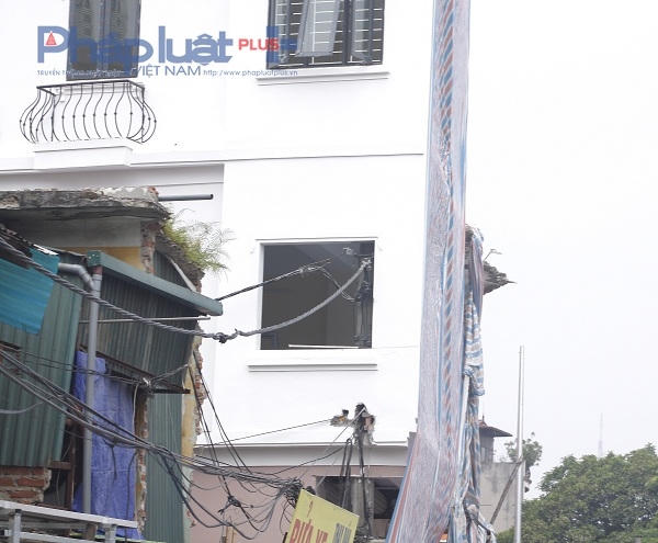Chiếc cột điện "mọc xuyên" lên đến từng 2 của ngôi nhà và phần ngọn chiếc cột điện được chủ ngôi nhà cắt ngắn lại để không bị ảnh hưởng đến mái của tầng 2.