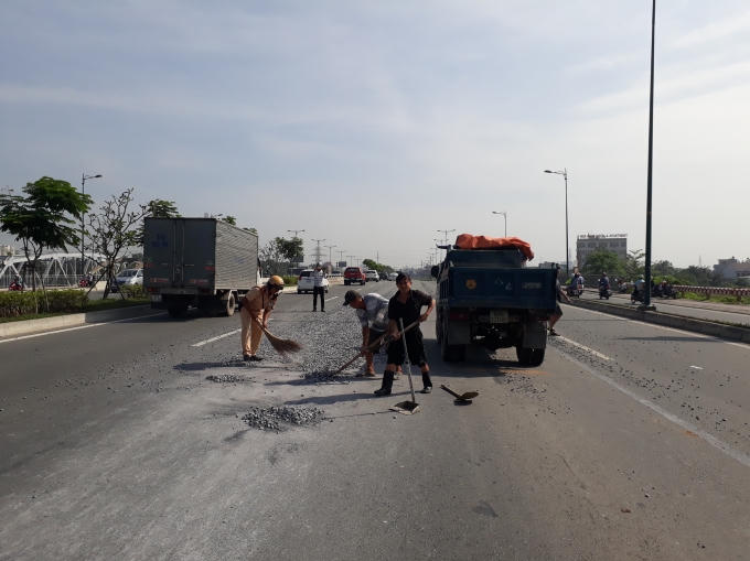 CSGT cùng người dân quét dọn đá rơi trên đường.