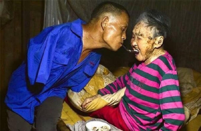 Hình ảnh người con trai dùng miệng để lấy cơm cho mẹ. (Nguồn: Facebook)
