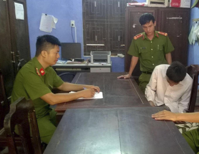 Đối tượng L&ograve;n (&aacute;o trắng) tại cơ quan C&ocirc;ng an.