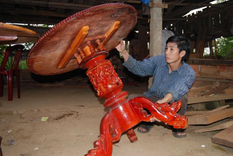 Một thợ trẻ ở Văn Hà đã tiếp thu được kỹ thuật đóng bàn tự xoay của cha ông (Ảnh: Tuổi trẻ).  