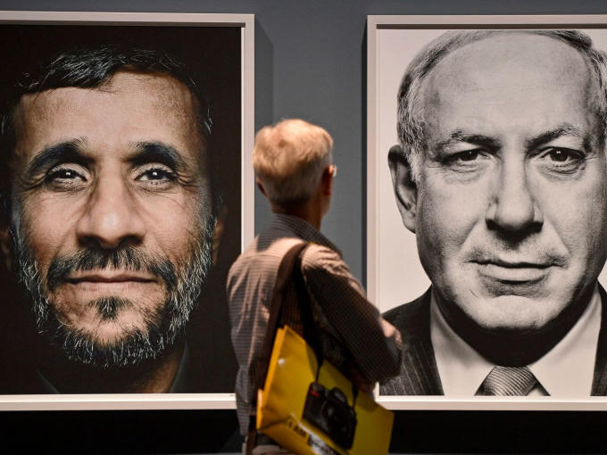 Một du khách nhìn lên chân dung Tổng thống Iran Mahmoud Ahmadinejad và Thủ tướng Israel Benjamin Netanyahu trong cuộc triển lãm "Faces of Power" in Cologne, năm 2012. Ảnh: AP.