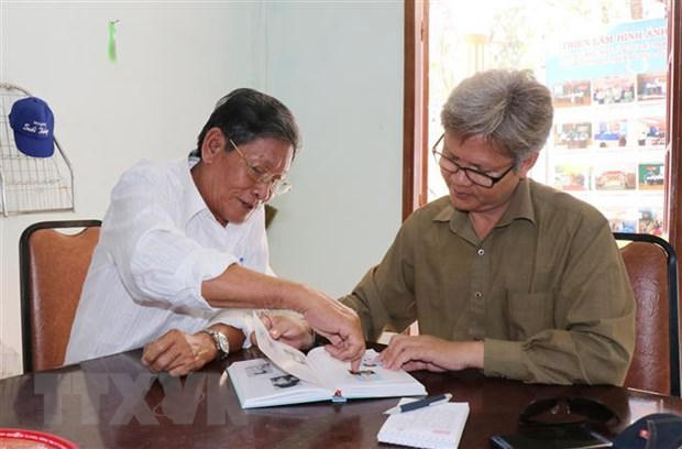 Đại úy Cao Hồng Ngọt (nguyên Đội trưởng Đội 5) giới thiệu những chiến tích được ghi trong sách của Đội 5, đơn vị hai lần được phong tặng Anh hùng Lực lượng Vũ trang nhân dân. (Ảnh: Tiến Lực/TTXVN)