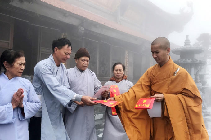 Sư thầy Thích Chân Hiền tặng bùa trì chú cầu an tới các Phật tử và du khách.
