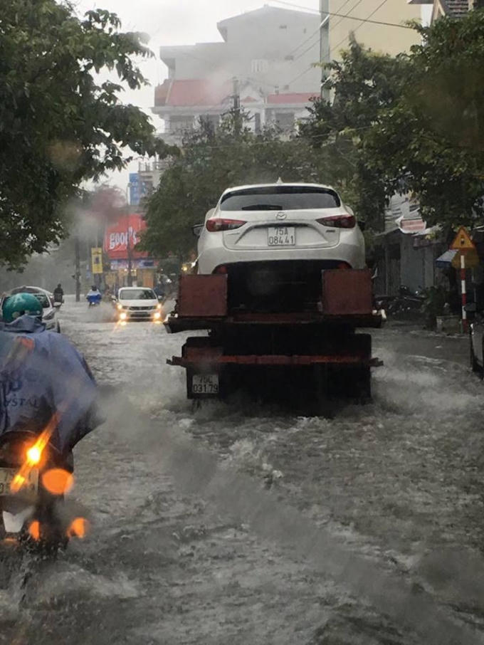 Một chiếc ô tô bị chết máy khi lưu thông qua đoạn đường ngập sâu phải cứu hộ. (Ảnh: Simla)