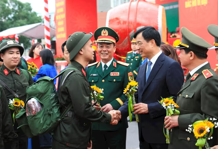 Bí thư Thành ủy Hà Nội Nguyễn Duy Ngọc tặng hoa động viên tân binh lên đường nhập ngũ. Ảnh: HNM