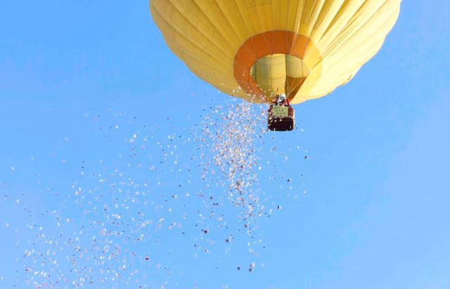 Rất nhiều phong bì lì xì chứa tiền được tác giả Phạm Tuấn Sơn rải ra từ khinh khí cầu bay trong sân vận động Tự Do, TP Huế sáng 16/6