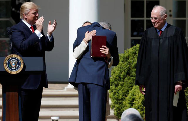 Tổng thống Trump vỗ tay chúc mừng trong khi ông Neil Gorsuch, người vừa tuyên thệ trở thành Thẩm phán Tòa án tối cao Mỹ, đang ôm vợ của mình tại Vườn Hồng, Nhà Trắng.