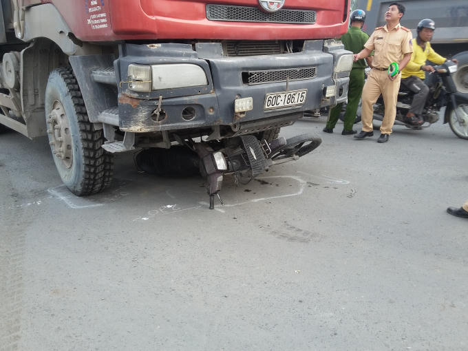 Chiếc xe máy bị cuốn vào gầm.