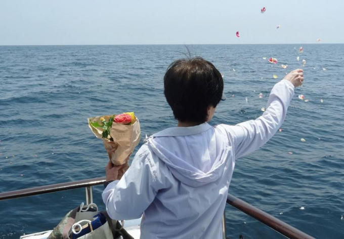 Tung cánh hoa vĩnh biệt người thân trong một đám tang ngoài cảng Manazuru, tỉnh Kanagawa, Nhật Bản.