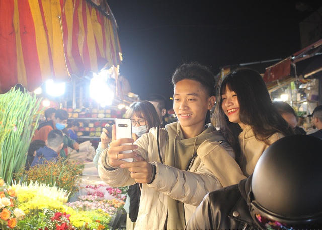 Nhiều bạn trẻ ngoài đến mua hoa còn tranh thủ check-in ở khung cảnh phiên chợ sôi động