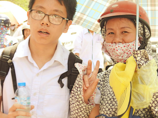 Người mẹ vui vẻ tạo dáng tay chào khi thấy ống kính máy ảnh.