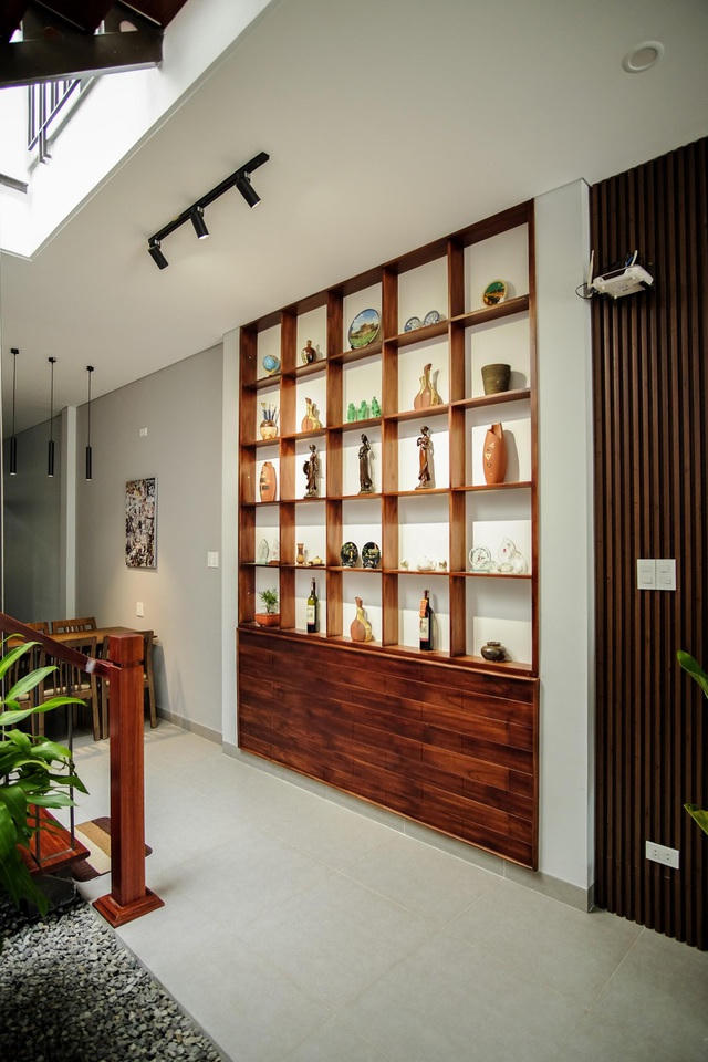 Kệ để đồ sát trần được đóng bằng gỗ với thiết kế đơn giản nhưng lại tiện nghi, vừa mở rộng diện tích lưu trữ, vừa để trang trí cho khu vực tiếp nối phòng khách - bếp ăn bớt trống trải.