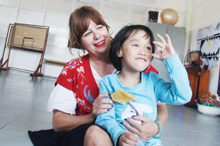 Cô Jackie bên một em nhỏ ở Trung tâm Kỳ Anh. (Ảnh: Báo Tiền Phong)