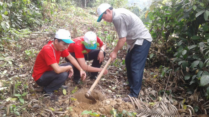Tình nguyện viên cùng với lãnh đạo địa phương trồng cây.