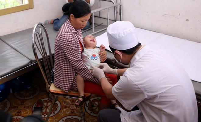 Khám cho trẻ bị mắc sùi mào gà do trước đây từng cắt bao quy đầu tại cơ sở của bà Hoàng Thị Hiền. (Ảnh: TTXVN)