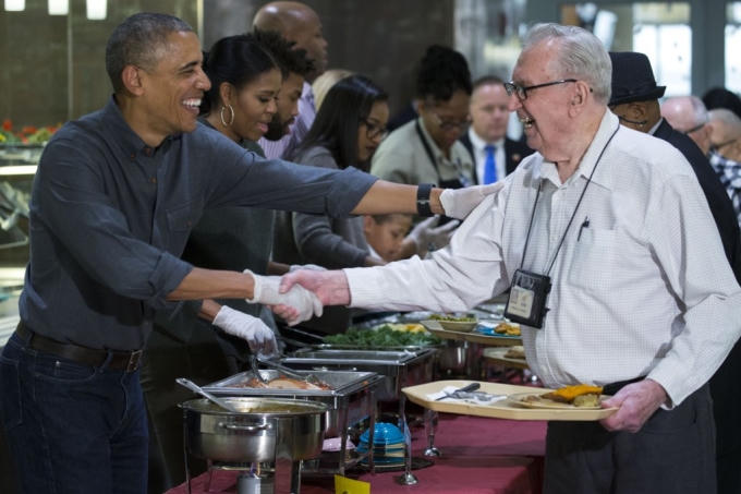 Gia đình Tổng thống Obama vui vẻ phục vụ bữa tối cho các cựu binh. Đệ nhất phu nhân Michelle phục vụ món rau chân vịt và đậu. (Ảnh: AP)