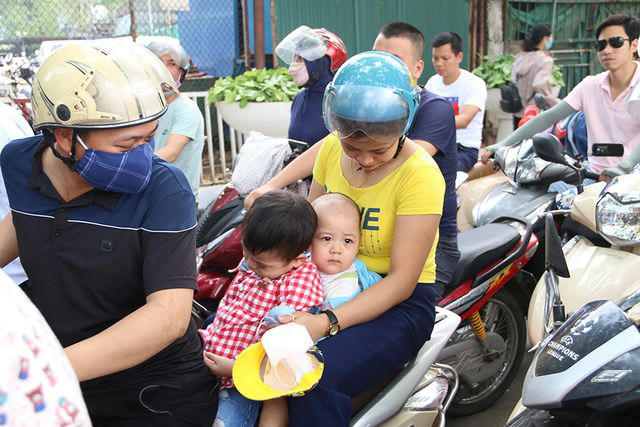 Một gia đình cho con nhỏ vào công viên chơi, tuy nhiên để có thể gửi được xe mua vé họ phải đợi nửa tiếng đồng hồ.